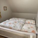 Bedroom with double bed, window, and sloped ceiling.