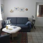 Living room with sofa, table, and rug. Door with tinted glass.