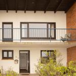 Two-story house with balcony, entrance, and windows