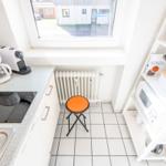 Kitchen with worktop, stove, coffee machine, and chair by window