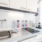 Kitchen with sink, induction cooktop, and coffee machine.