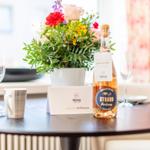 Table with flowers, wine bottle, and welcome card.