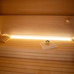 Sauna mit Holzbänken, Handtüchern und Flüssigkeiten
