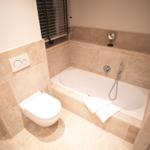 Bad mit Badewanne, Toilette und Fenster mit Jalousie