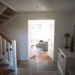 Eingang mit Treppe, Spiegel und Schrank. Durchgang zum Wohnzimmer.