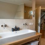 Badezimmer mit Waschbecken, Spiegel und Dusche.