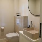 Badezimmer mit Toilette, Waschbecken und Spiegel