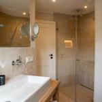 Bad mit Dusche, Waschbecken und Spiegel