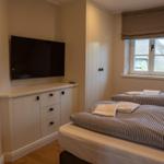Zimmer mit zwei Betten, TV und Fenster mit Blick auf Dach