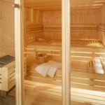 Holzsauna mit mehreren Sitzbänken und einem Eimer.