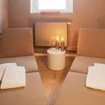 Zwei Liegen mit Handtüchern, Tisch mit Kerzen und Heizkörper an Wand