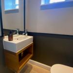 Badezimmer mit Waschbecken, Spiegel und Toilette