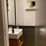 Badezimmer mit Waschbecken, Spiegel und Fenster