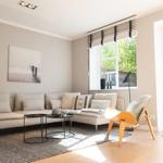 Wohnzimmer mit Sofa, Tisch und Stuhl vor Fenster