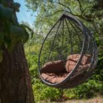 Hängesessel mit Kissen im Wald unter Bäumen
