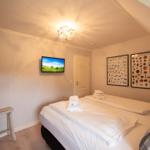 Bedroom with double bed, TV, and wall posters.