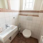 Bathroom with toilet, sink, and window