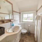 Bathroom with sink, toilet, and window