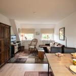 Living and dining area with sofa, dining table, and antique cabinet.