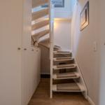 Treppenhaus mit weißer Treppe und Kinderhaken an der Wand