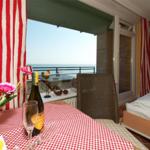 Tisch mit Tischdecke, Weinflasche und Blick aufs Meer