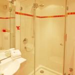 Badezimmer mit Dusche, Waschbecken und Handtüchern