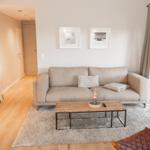 Wohnzimmer mit Sofa, Couchtisch und Schiebetür zur Terrasse.