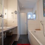 Bathroom with bathtub, sink, and mirror