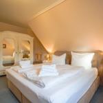 Schlafzimmer mit Doppelbett, Schrank und Nachttisch.