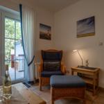 Living area with armchair, table, and view of terrace