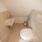 Dusche mit Toilette und Waschbecken unter Dachschrägen