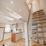 Moderne Küche mit Holzoptik und Treppe zur oberen Etage.