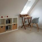 Bedroom with desk, bookcase, and skylight.