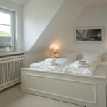 Bedroom with double bed, window, and nightstands.
