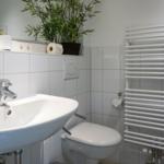 Bathroom with sink, toilet, and heater.