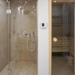 Shower with shower head and sauna with wooden bench