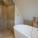Bath with freestanding bathtub and shower with glass enclosure.