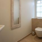 Bathroom with mirror, toilet, and sink.
