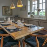Dining room with wooden table, chairs, and window view
