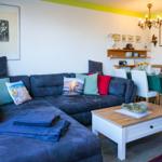 Wohn- und Essbereich mit Sofa, Tisch und Wanddekoration.