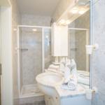 Badezimmer mit Dusche, Waschbecken und Spiegelschrank