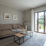 Wohnzimmer mit Sofa, Couchtisch und Terrassentür.