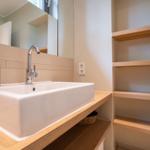 Waschbecken mit Spiegel und Holzregalen