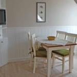 Dining area with table, four chairs, and TV mounted on the wall.
