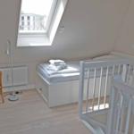 Room with crib, bed, and window
