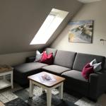 A living room with gray sofa, wooden table, and skylight.