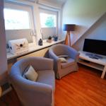 Zwei Sessel, Fernseher und Fenster mit Blick nach draußen.