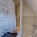 Bathroom with bathtub, shower, and towel warmer with towels.