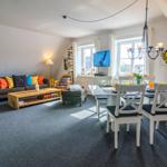 Living and dining area with sofa, dining table, and windows.