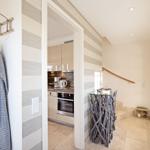 Entrance with coat rack, kitchen area, and staircase